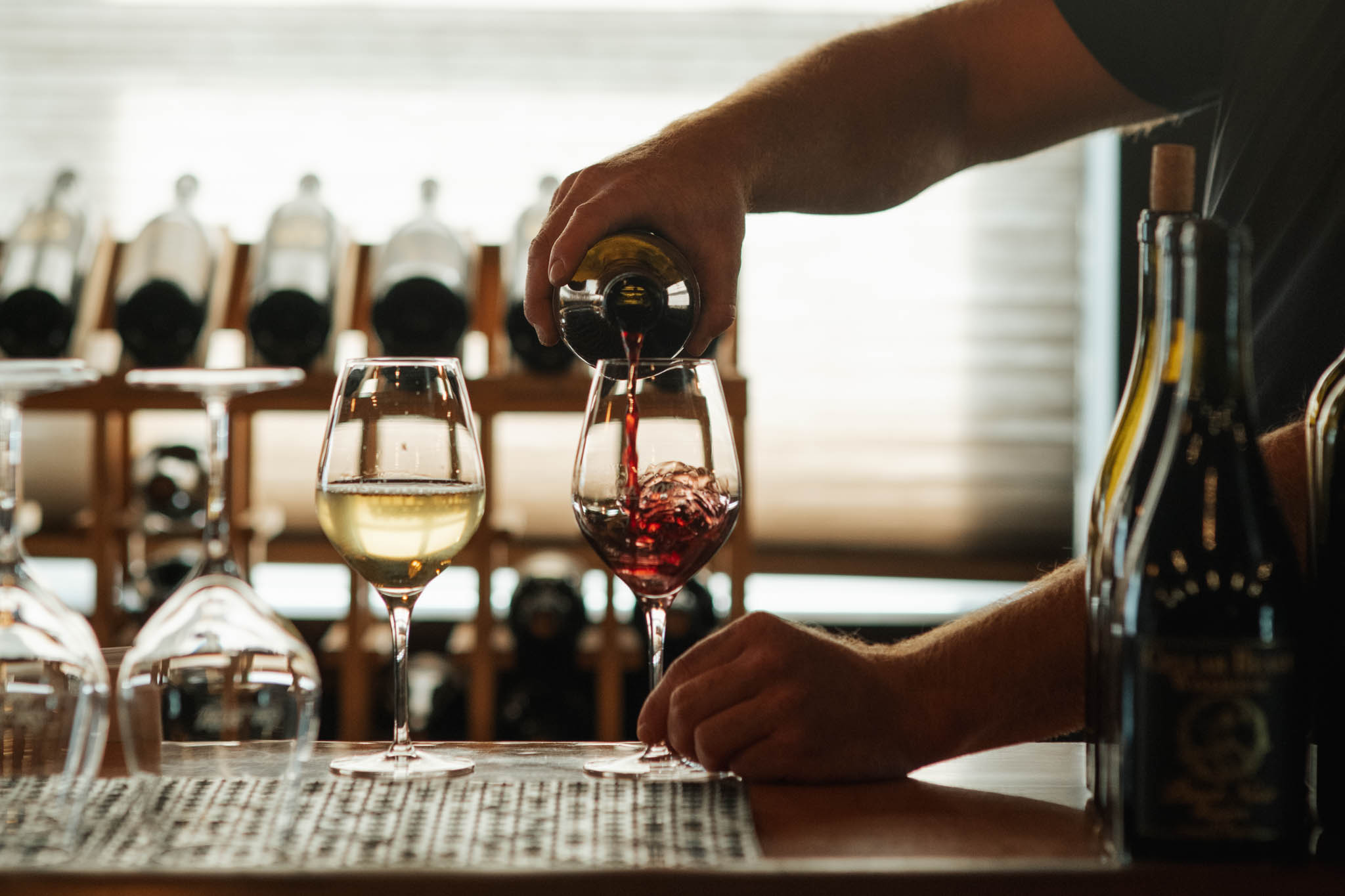 Pouring Cellar Beast red wine at the tasting room bar